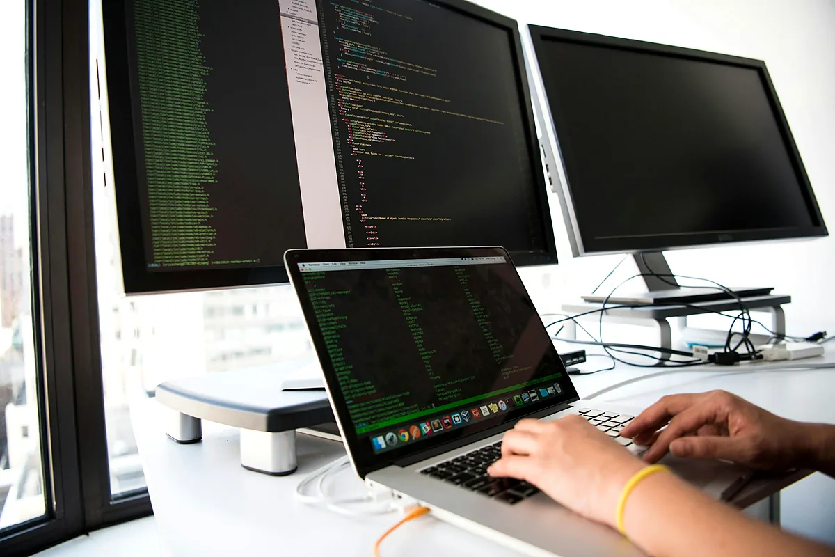Analyst reviewing reports on screens at a workstation
